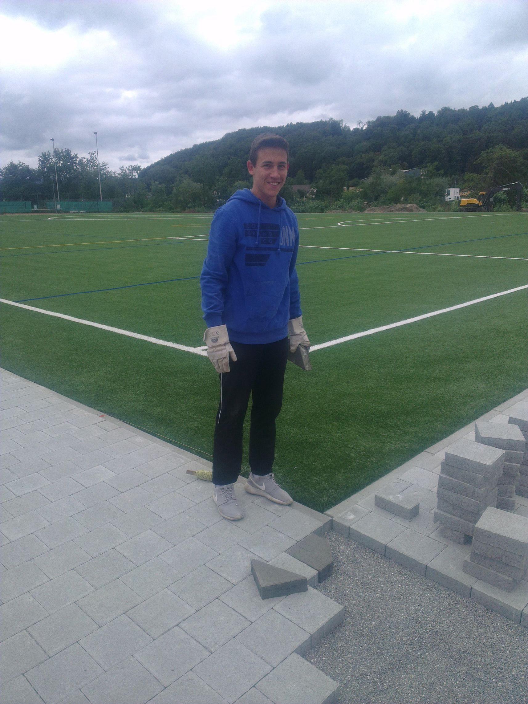 Damian Granacher beim Verlegen der letzten Steine. alt