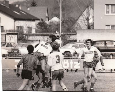 VfB Waldshut - SV Dogern
Saison 1985/86. Nach dem strengen Frost im Winter 85/86. Da wurde die VfB-Hecke (im Hintergrund) total gestutzt. Wir sehen beim Kopfball Thomas Jehle, Axel Knobloch (Nr. 3) und Uwe Bartram zu Zeiten in denen Schienbeinschoner noch keine Pflicht waren.
